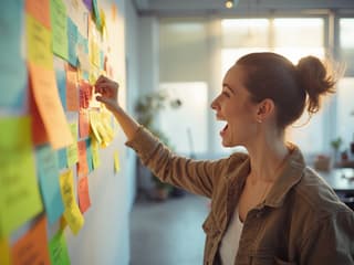 Excited person brainstorming with colorful sticky notes in a bright studio
