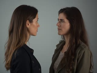 Studio portrait of two people having a serious conversation, with thoughtful expressions