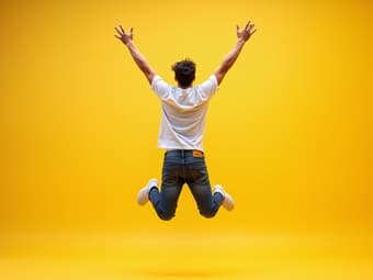 Vibrant studio shot of a person jumping with arms raised, energetic pose, bright background